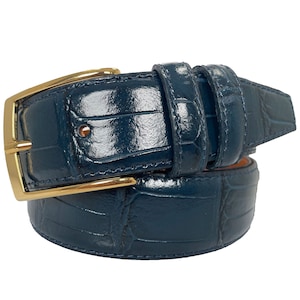 May include: A dark blue leather belt with a gold buckle. The belt is made of alligator skin and has a glossy finish.