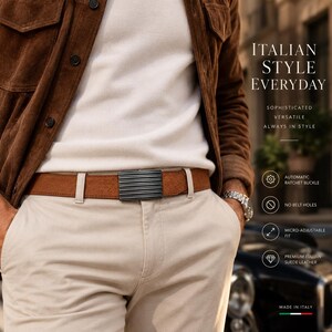 May include: A brown suede leather belt featuring a black metallic rectangular buckle with horizontal ridges. The belt is worn with beige trousers and a white shirt under a brown suede jacket. Text on the image reads: ITALIAN STYLE EVERYDAY.