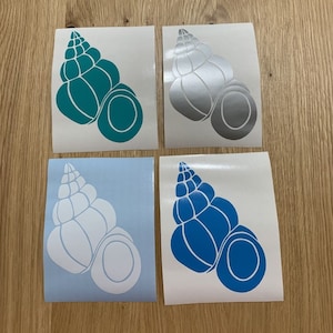 May include: Four seashell-shaped vinyl stickers in various colors: teal, silver, white, and blue. Each sticker features a detailed outline of a conch shell design, perfect for decorating laptops, water bottles, or other items.