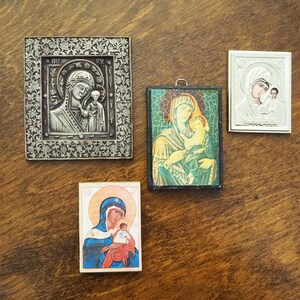 Pu&ograve; includere: Quattro icone religiose incorniciate che raffigurano la Vergine Maria e il bambino Ges&ugrave;. Le icone sono in stili e colori diversi, con dettagli in argento, oro e dipinti.