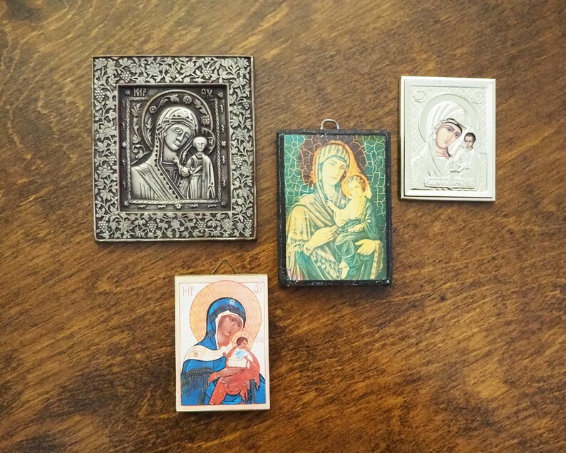 Pu&ograve; includere: Quattro icone religiose incorniciate che raffigurano la Vergine Maria e il bambino Ges&ugrave;. Le icone sono in stili e colori diversi, con dettagli in argento, oro e dipinti.