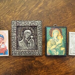 Pu&ograve; includere: Quattro icone religiose incorniciate che raffigurano la Vergine Maria e il bambino Ges&ugrave;. Le icone sono in stili e colori diversi, con cornici in argento, oro e legno.