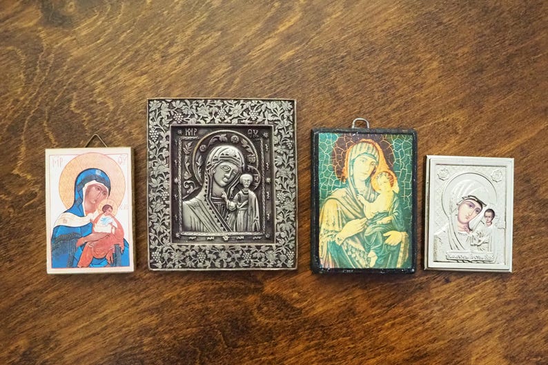 Pu&ograve; includere: Quattro icone religiose incorniciate che raffigurano la Vergine Maria e il bambino Ges&ugrave;. Le icone sono in stili e colori diversi, con cornici in argento, oro e legno.