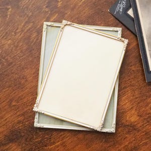 Könnte beinhalten: Ein Set aus drei Keramikbechern mit gesprenkelter, matter Oberfläche. Die Becher sind in Creme-, Hellgrau- und Dunkelgrautönen gehalten. Jeder Becher hat ein schlichtes, minimalistisches Design.
