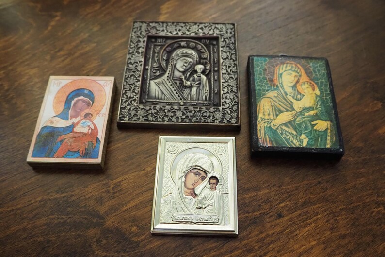 Pu&ograve; includere: Quattro icone religiose incorniciate con immagini della Vergine Maria e del bambino Ges&ugrave;. Le icone sono in diversi stili e colori, tra cui argento, oro e blu.