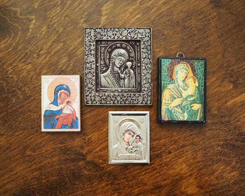 Pu&ograve; includere: Quattro icone religiose incorniciate che raffigurano la Vergine Maria e il bambino Ges&ugrave;. Le icone sono in stili e colori diversi, tra cui argento, oro e blu.