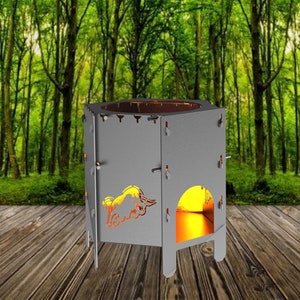 Puede incluir: Un hogar de metal gris con un diseño recortado de un ciervo. El hogar está en una plataforma de madera con un fondo de bosque verde.