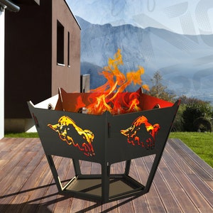 May include: A black metal fire pit with a hexagonal base and a square top. The fire pit has two bull silhouettes cut out on the sides. The fire pit is on a wooden deck with a view of mountains in the background.