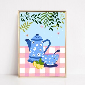 Peut inclure: Une théière et une tasse à thé bleues avec des motifs floraux blancs sur une nappe à carreaux rose et blancs. La théière a un bec verseur et une poignée. La tasse à thé a une poignée et une soucoupe. Il y a des citrons et des feuilles vertes sur la nappe.