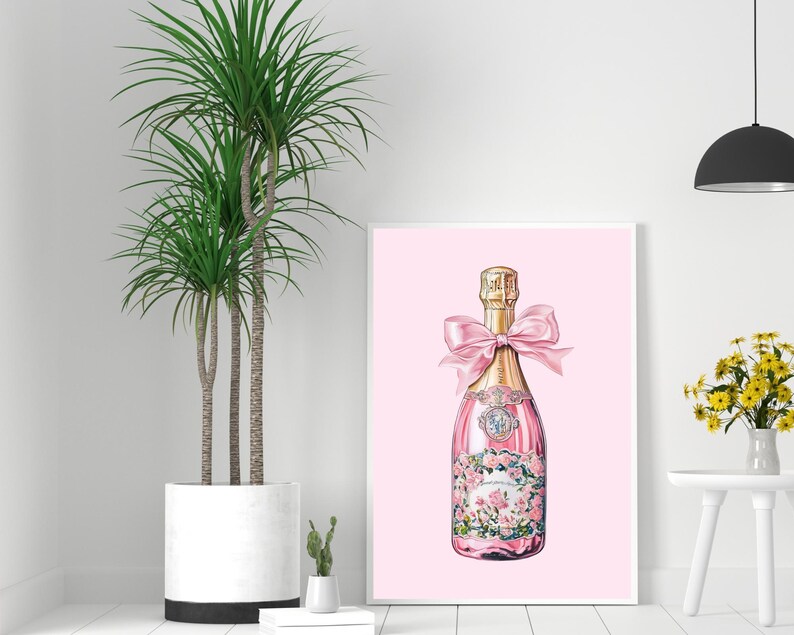 May include: A pink champagne bottle with a gold top and a pink bow. The bottle is decorated with pink flowers and has a pink background.