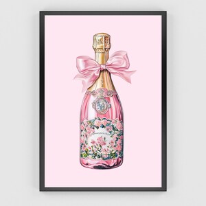 May include: A pink champagne bottle with a gold label and a pink bow. The bottle is decorated with floral designs and has a gold stopper.