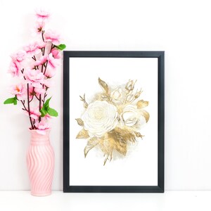 May include: A framed art print featuring a watercolor illustration of white and gold roses. The artwork is in a black frame and is displayed next to a pink vase with pink flowers. The overall aesthetic is elegant and floral.