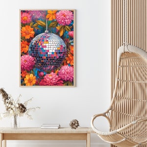 May include: A silver disco ball surrounded by pink, orange, and yellow flowers. The flowers are in bloom and have a vibrant, colorful appearance.