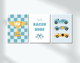 May include: Three framed prints with a racing theme. One features a gold trophy on a checkered background. Another reads "little RACER DUDE" with crossed flags. The third shows three vintage race cars in blue and yellow.