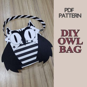May include: A black and white owl-shaped bag with a striped body, star-patterned face, and a striped handle. The text PDF PATTERN DIY OWL BAG is displayed to the right of the bag. The design features large eyes and wing-like side panels.