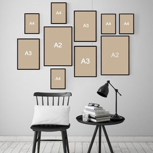 May include: A template showing how to arrange different sizes of prints on a wall. The sizes are labeled A2, A3, and A4. The template includes a black chair with a white pillow, a black side table with a lamp, and a stack of books.