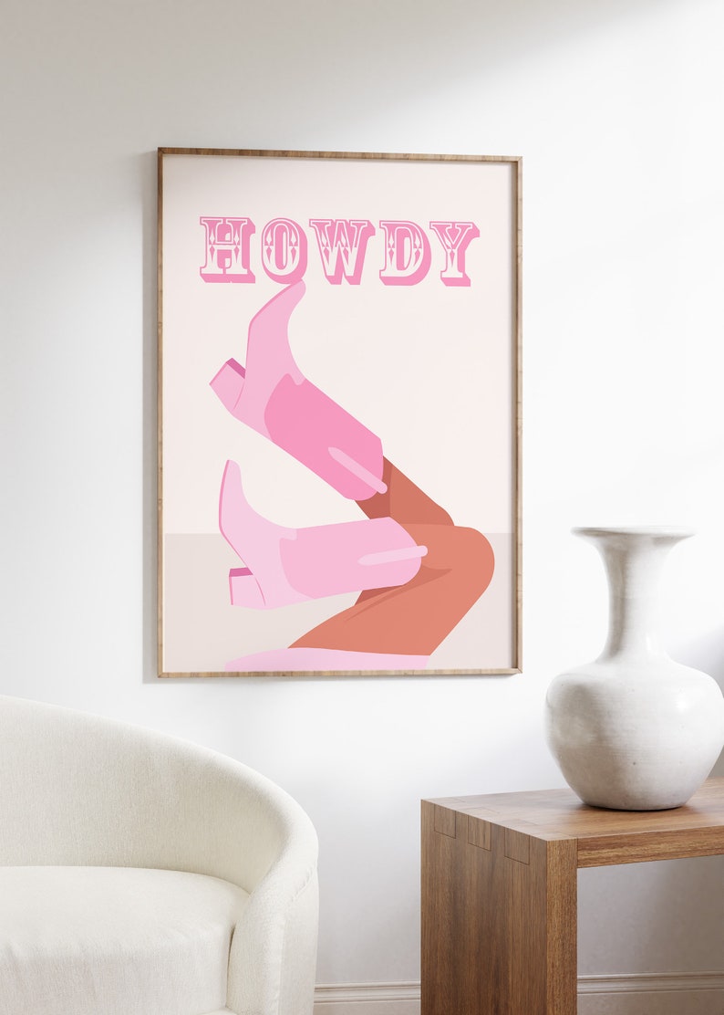 Pu&ograve; includere: Un poster rosa e bianco con la parola "HOWDY" in lettere rosa con contorno bianco. Il poster presenta un paio di stivali da cowboy rosa con una gamba color bronzo che sporge dalla parte superiore degli stivali.