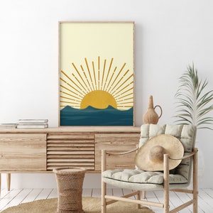 May include: A digital print of a minimalist sun rising over a blue ocean. The sun is yellow and the rays are gold. The ocean is a deep blue with waves. The background is a light yellow.