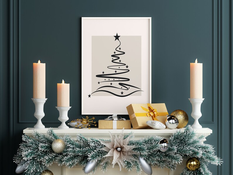 May include: A white mantelpiece decorated with a green garland, gold and silver ornaments, and two white candle holders with lit candles. A framed print of a black abstract Christmas tree design hangs above the mantel.