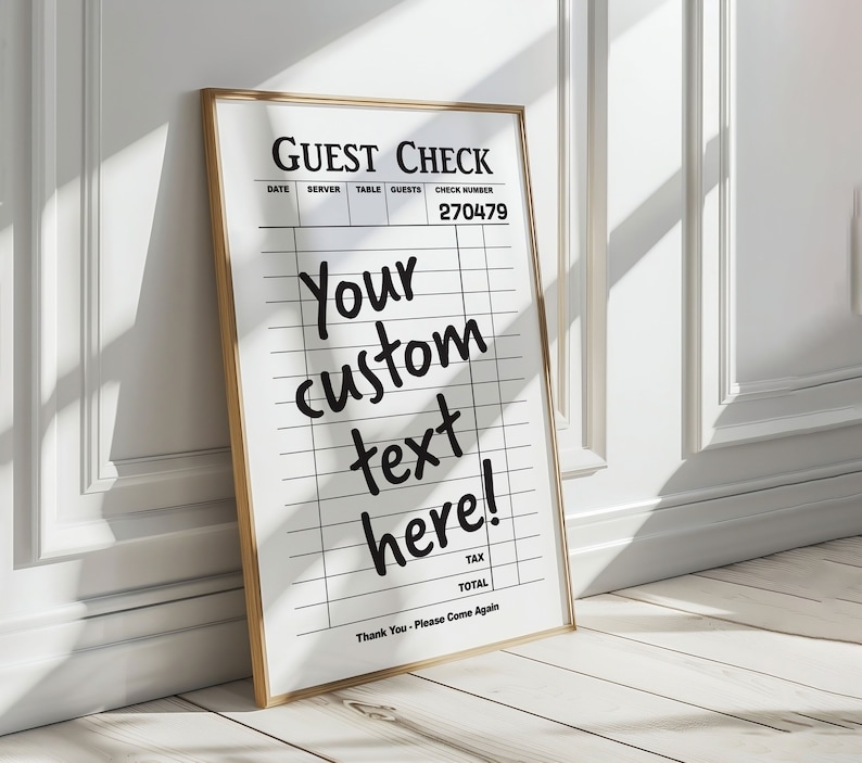 May include: A white guest check with a black frame. The check has a grid pattern and the text "GUEST CHECK", "DATE", "SERVER", "TABLE", "GUESTS", "CHECK NUMBER", "270479", "Your custom text here!", "TAX", "TOTAL", and "Thank You - Please Come Again".