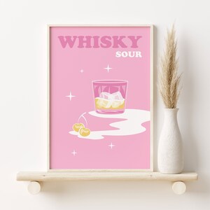 Puede incluir: P&oacute;ster imprimible rosa con el texto "WHISKY SOUR" en letras blancas. En el centro del p&oacute;ster se representa un vaso de whisky sour con hielo y cerezas.