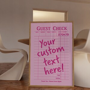 May include: Pink guest check with a wooden frame. The check has a pink grid pattern and the text "GUEST CHECK", "DATE", "SERVER", "TABLE", "GUESTS", "CHECK NUMBER", "270479", "Your custom text here!" and "Thank You - Please Come Again".