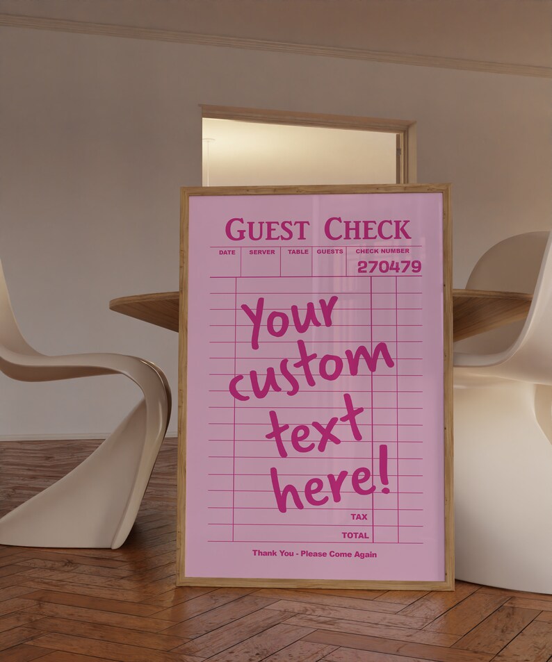 May include: Pink guest check with a wooden frame. The check has a pink grid pattern and the text "GUEST CHECK", "DATE", "SERVER", "TABLE", "GUESTS", "CHECK NUMBER", "270479", "Your custom text here!" and "Thank You - Please Come Again".