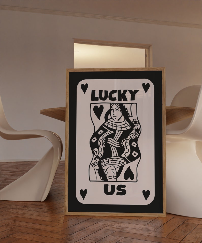 Pu&ograve; includere: Stampa incorniciata in bianco e nero di una carta da gioco della regina di cuori con il testo "LUCKY US" su sfondo bianco.