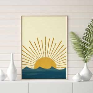 May include: A digital art print featuring a stylized sun rising over a blue and yellow landscape. The sun has a yellow center and gold rays. The landscape is a series of blue waves.