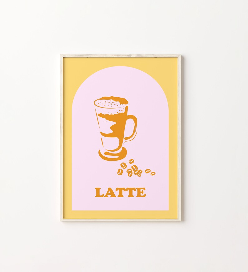 May include: A framed print with a yellow and pink background. The print features a stylized illustration of a latte in a glass with a brown and white design. The word "LATTE" is printed in orange below the illustration.