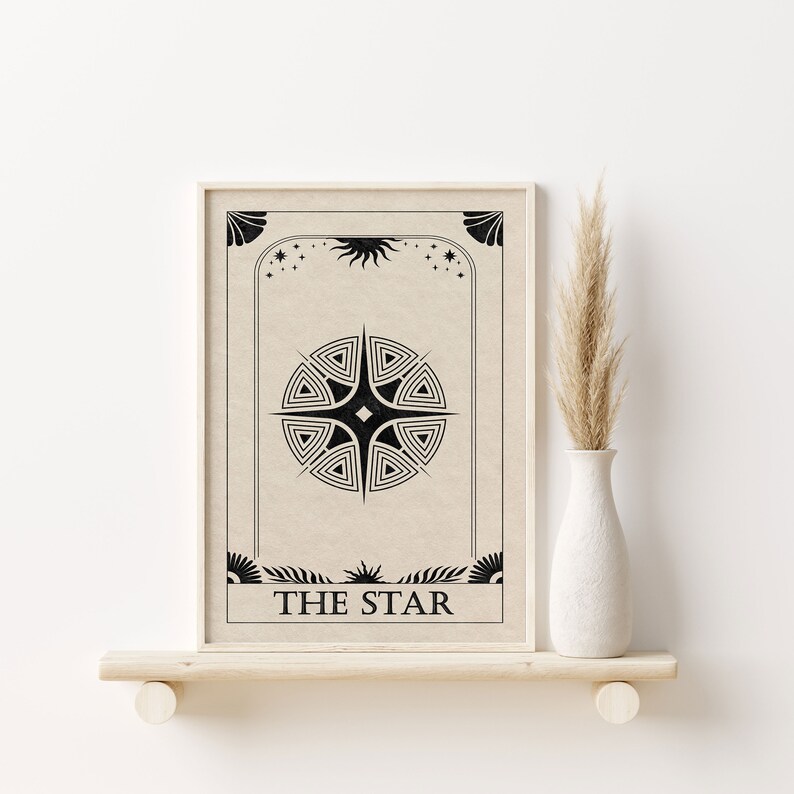 May include: A beige framed print with a black and white illustration of a star with the text "THE STAR" at the bottom.