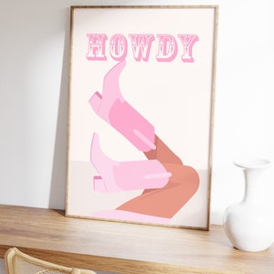 Pu&ograve; includere: Un poster rosa e bianco con la parola "HOWDY" in grandi lettere rosa. Il poster presenta un paio di stivali da cowboy rosa con una gamba abbronzata che sporge dalla parte superiore di ogni stivale.