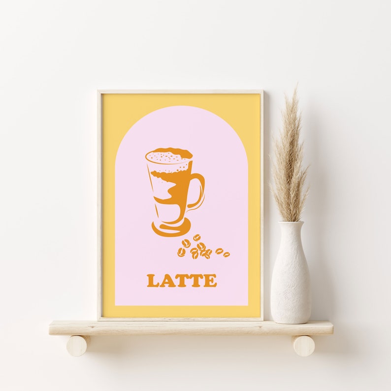 May include: A printable art print with a yellow background and a pink arch. Inside the arch is a stylized illustration of a latte in a glass with a brown and white design. The text "LATTE" is below the glass and there are brown coffee beans scattered around the glass.
