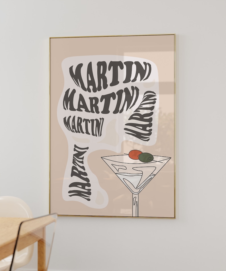 May include: A beige poster with a gold frame features a stylised illustration of a martini glass with olives and the word "MARTINI" repeated in a swirling pattern.