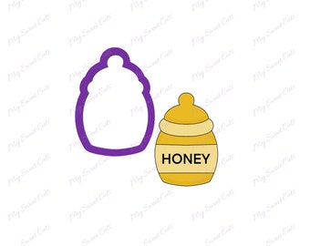 May include: A purple cookie cutter shaped like a honey pot with a lid. A yellow honey pot with a white lid and the word "HONEY" printed on the front.