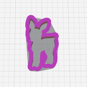 May include: A purple plastic cookie cutter shaped like a standing deer. The cutter has a detailed design with a rounded head and a long neck.