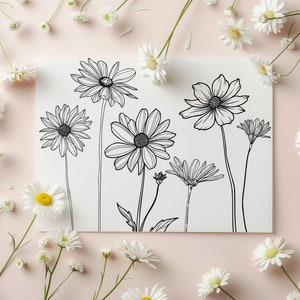 May include: A white card with black line drawings of various flowers, including daisies and cosmos. The card is surrounded by real white daisies on a pink background.