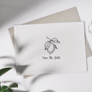 Pu&ograve; includere: Un biglietto bianco con un'illustrazione in bianco e nero di un ramo di limone e il testo "Save the Date" stampato su di esso.