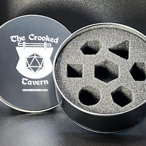 Pu&ograve; includere: Una scatola di metallo nero con un coperchio con la scritta "The Crooked Tavern" e un logo a scudo. All'interno, un inserto in schiuma contiene varie forme di dadi. La scatola &egrave; progettata per riporre i dadi, probabilmente per i giochi da tavolo.
