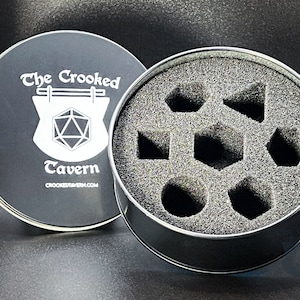 May include: A black metal tin with a foam interior for storing dice. The lid features a white logo that says "The Crooked Tavern" with a stylized image of a tavern sign and a 20-sided die.