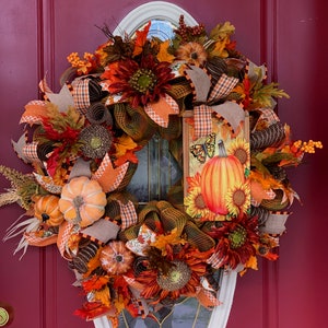 Corona de flores y calabazas de otoño
