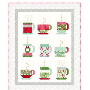 May include: A quilt pattern featuring nine colorful mugs with steam rising from them. The quilt is surrounded by a white border with a gray and white patterned border. The text "In From the Cold" is at the top of the quilt and the text "Kate Spain" is at the bottom.