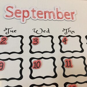 May include: A white magnetic calendar with the word "September" at the top. The days of the week are labeled "Tue", "Wed", "Thu", and "Fri". The numbers 2, 3, 4, 5, 9, 10, 11, and 12 are displayed in red on the calendar.