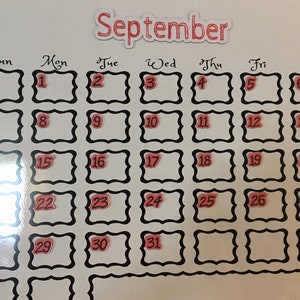 May include: A white calendar with black borders and red numbers. The calendar is for September.