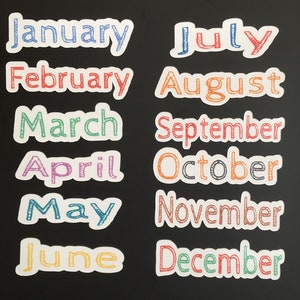 May include: Twelve colorful, handwritten month names on white paper circles, arranged in two rows of six. The months are January, February, March, April, May, June, July, August, September, October, November, and December.