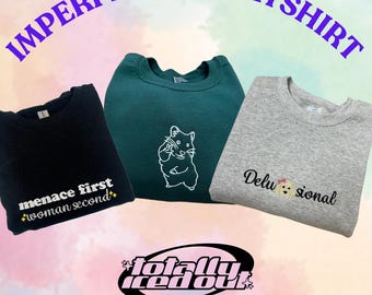 May include: Three sweatshirts in black, green, and gray, each with unique white text and graphics. The black sweatshirt says "menace first woman second". The green sweatshirt features a hamster graphic. The gray sweatshirt says "Delusional". The words "IMPERFECT SWEATSHIRT" are arched above.
