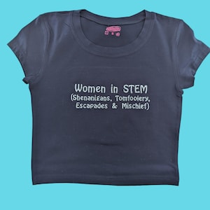 May include: A dark blue t-shirt with the text "Women in STEM (Shenanigans, Tomfoolery, Escapades & Mischief)" printed in white.