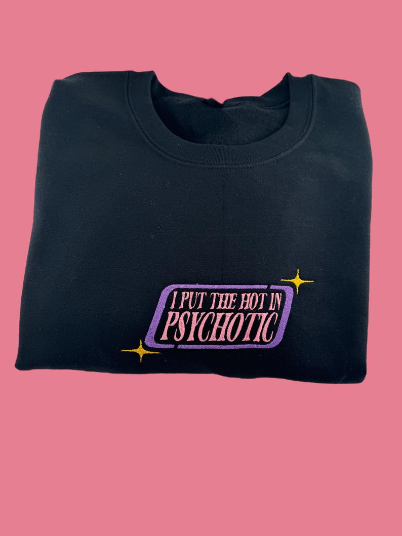 A black sweatshirt with a purple and yellow graphic on the front, which says "I PUT THE HOT IN PSYCHOTIC" in a stylized font.