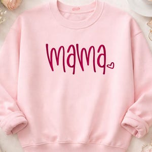 A pink sweatshirt with the word "mama" printed on it, along with a heart symbol.