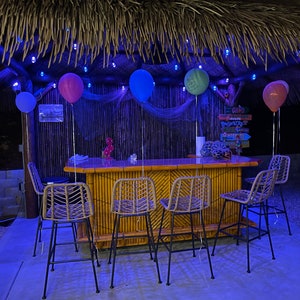 Large bamboo tiki bar with wheels, storage, electrical outlet, footrail. Mini fridge, wine cooler ready backyard patio tiki hut palapa bar.